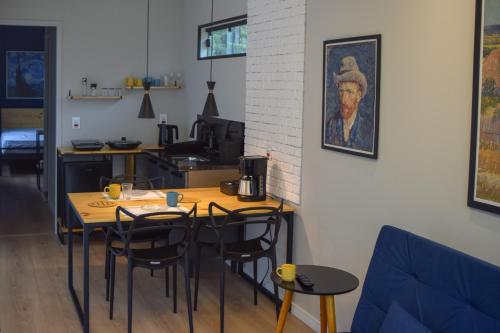 a dining room with a table with chairs and a painting at Noite Estrelada Holambra in Holambra