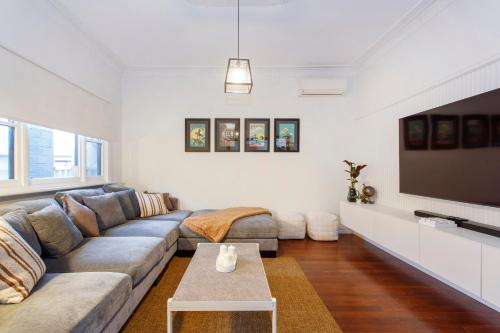 a living room with a couch and a flat screen tv at Scarborough Coastal Escape in Perth