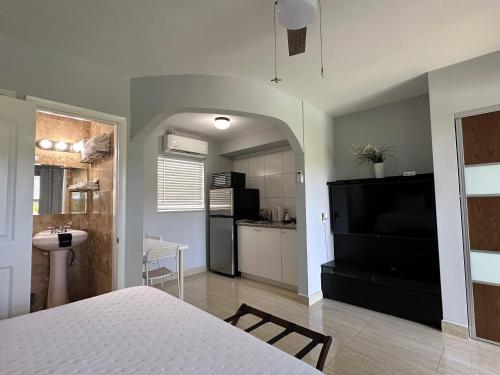 a bedroom with a white bed and a kitchen at White Horse Motel in Lake Worth