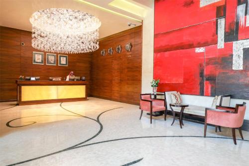 a lobby with a chandelier and a table and chairs at Kempinski Al Othman Hotel Al Khobar in Al Khobar