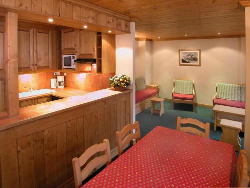 une cuisine avec un comptoir, une table et des chaises dans l'établissement Chalet in Les Deux Alpes near Ski Lift, à Les Deux Alpes