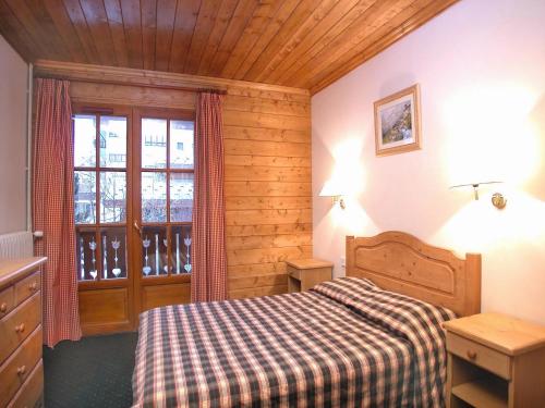 une chambre avec un lit et une grande fenêtre dans l'établissement Chalet in Les Deux Alpes near Ski Lift, à Les Deux Alpes