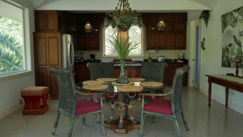 a kitchen with a table with chairs and a refrigerator at Villa Quebrada Estate in Montezuma