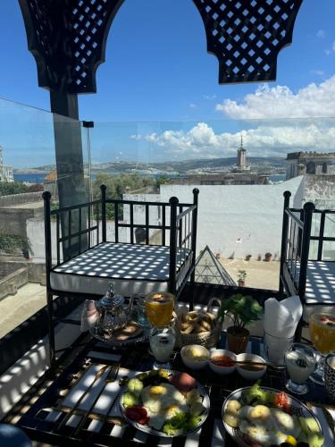 a table with food on it with a view of the water at Riad M'Barka in Tangier