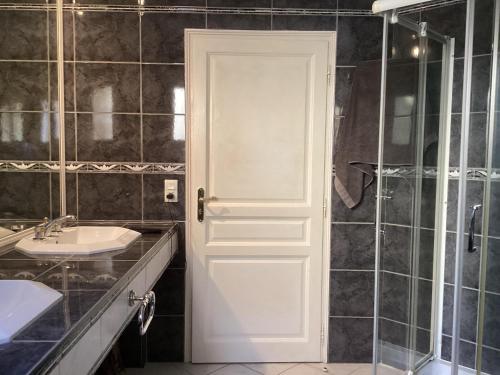 La salle de bains est pourvue d'une porte blanche et d'un lavabo. dans l'établissement Villa in France with Private Pool & Garden, à Prades-sur-Vernazobre