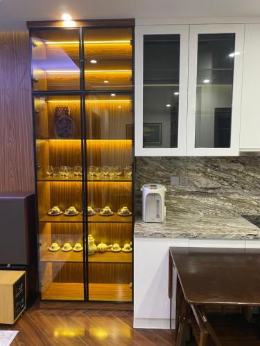 a kitchen with a cabinet filled with wine glasses at 7Homestay in Hai Phong