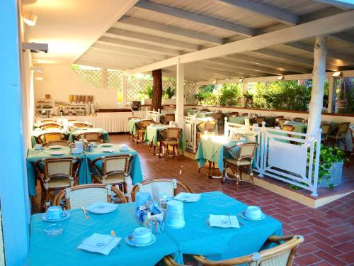 a restaurant with tables and chairs with blue table cloth at Hotel Meridiana in Marina di Campo