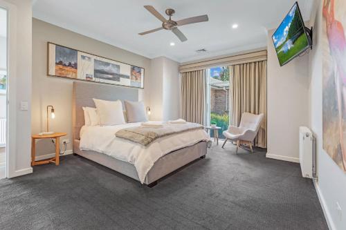 a bedroom with a bed and a flat screen tv at Blair Street - Luxury Home with Pool and Theatre in Moama