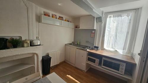 une petite cuisine avec un évier et une fenêtre dans l'établissement Au Vieux Palais - City Center Studio, à Rouen