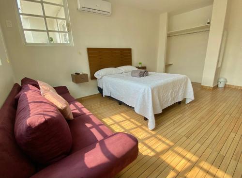 a living room with a bed and a couch at Ubicación top: Depto. a 3 min de la playa in Veracruz