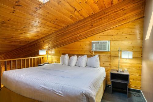 a bedroom with a bed in a wooden room at Super 8 by Wyndham Sturgis in Sturgis