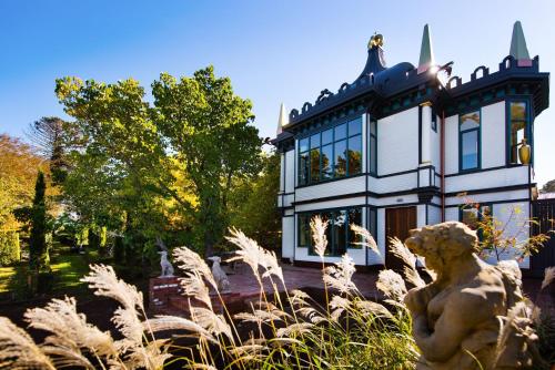 a house with a statue in front of it at Montacute Pavilion and Gardens in Daylesford