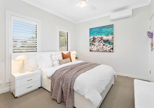 a white bedroom with a bed and a window at The Great Escape at Shell Cove in Dunmore