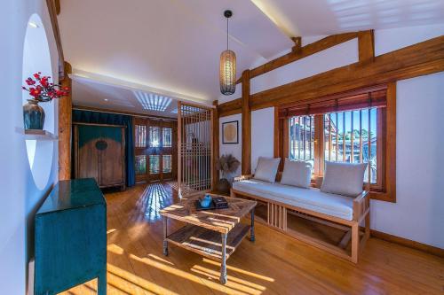 a living room with a couch and a table at Lijiang half yard hotel in Lijiang