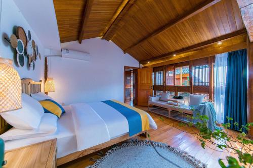 a bedroom with a large bed and a living room at Lijiang half yard hotel in Lijiang