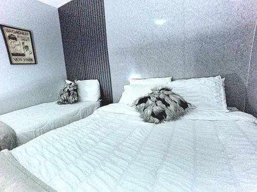 a bedroom with two beds with white sheets at BUSHWA APARTMENTS # 4 , 5 estrellas in Oranjestad