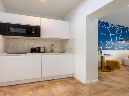une cuisine avec des armoires blanches et un micro-ondes dans l'établissement Charming studio - 2P - Pigalle Sacré-C ur, à Paris