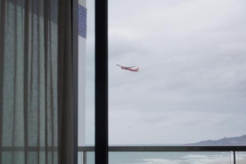 a plane flying over the water through a window at The Lagoon Cam Ranh - Your Perfect Getaway - Free room upgrade in Cam Ranh International Airport