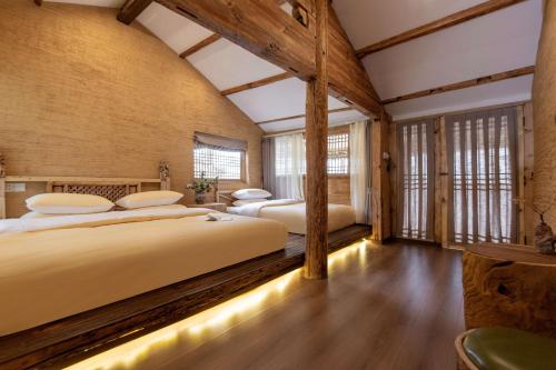 two beds in a room with wooden walls at Lijiang half yard hotel in Lijiang