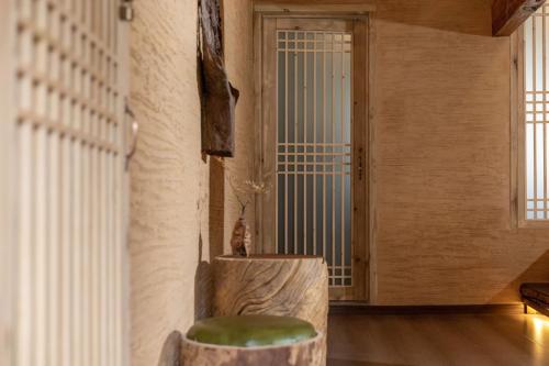 a room with a chair and a door with a window at Lijiang half yard hotel in Lijiang