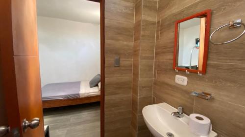 a bathroom with a sink and a mirror and a bed at Amazonas magic in Leticia