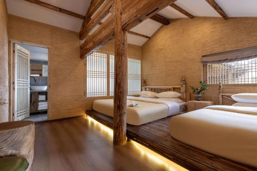 a bedroom with three beds in a room at Lijiang half yard hotel in Lijiang