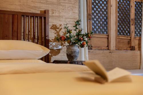 a bedroom with two beds and a vase with flowers at Lijiang half yard hotel in Lijiang