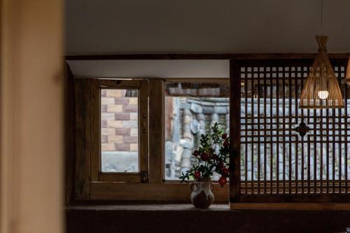 a window with a vase with a plant in it at Lijiang half yard hotel in Lijiang