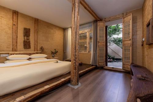 a bedroom with a large bed and a window at Lijiang half yard hotel in Lijiang