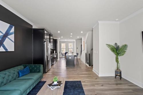 a living room with a green couch and a table at Luxurious King 3BR Townhouse Mins to Uptown CLT! in Charlotte