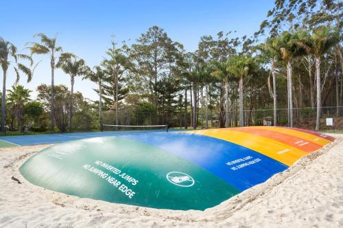 a volleyball court in the sand on a beach at Wairo Beach Holiday Park in Lake Tabourie