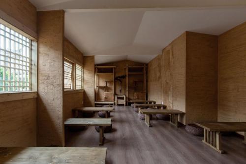 an empty room with wooden tables and benches at Lijiang half yard hotel in Lijiang