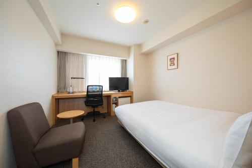 a hotel room with a bed and a desk and a chair at En Hotel Akita エンホテル秋田 in Akita