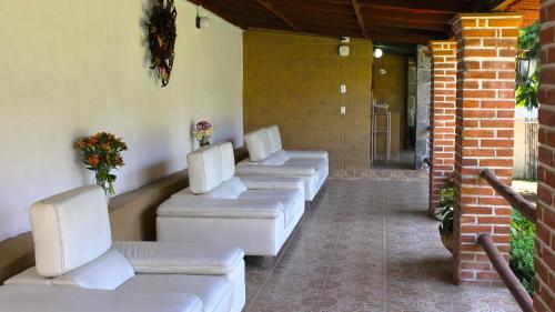 a row of white couches on a patio at Hotel Boutique Bacaanda in Tepoztlán
