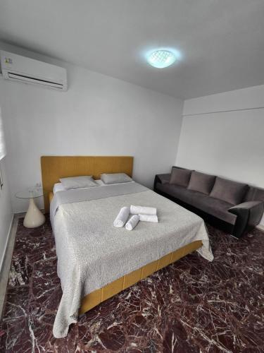 un dormitorio con una cama y un sofá en Luxury Angel Apartments 1, en Paralia Katerinis
