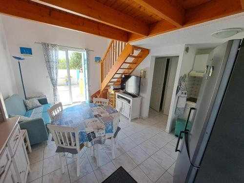 une cuisine et une salle à manger avec une table et des chaises dans l'établissement Charmante maison près du golf et plage avec terrasse et parking - FR-1-323-514, à Saint-Jean-de-Monts
