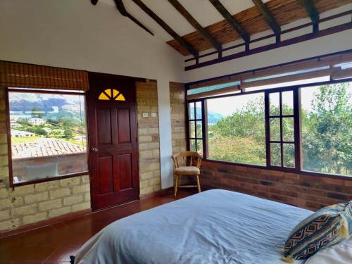 ein Schlafzimmer mit großem Bett und Fenster in der Unterkunft Casa Finca Los Arrayanes, spectacular views! in Villa de Leyva