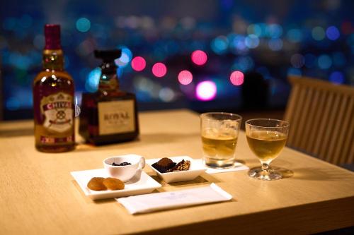 a table with two glasses and a bottle of alcohol at Cerulean Tower Tokyu Hotel, A Pan Pacific Partner Hotel in Tokyo
