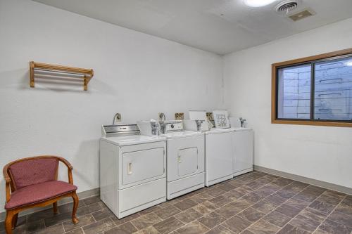 a room with white cabinets and a chair and a window at Super 8 by Wyndham Sturgis in Sturgis