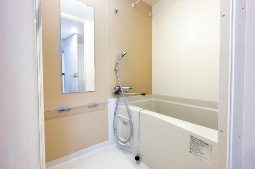 a bathroom with a shower and a bath tub at Laluna Higashiikebukuro in Tokyo