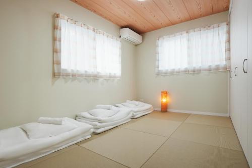 a room with four white mattresses on the floor at 大阪指定特区民泊小田別荘天王寺店OdaVillaTennoji in Osaka