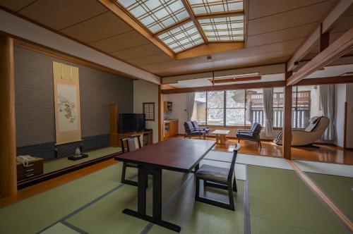 a living room with a wooden table and chairs at Seifutei in Inawashiro