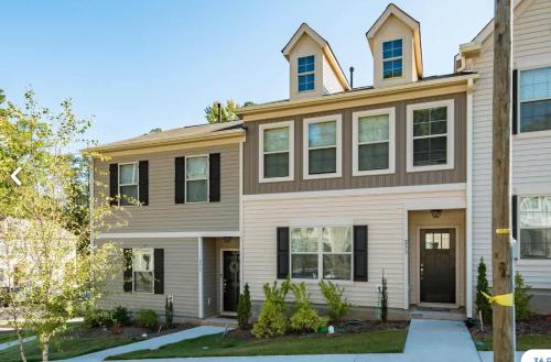 una casa grande en blanco y negro en Upscale King 3BR Townhouse Mins to Cary & NC State, en Raleigh
