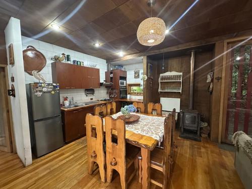 a kitchen with a table and a refrigerator at Casa Llallalca in Neltume