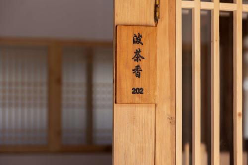a wooden door with asian writing on it at Lijiang half yard hotel in Lijiang