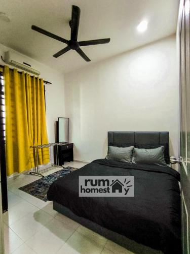 a bedroom with a bed with a fan and yellow curtains at RumaHomestay in Pekan
