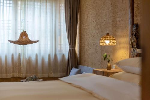 a bedroom with two beds and a window at Lijiang half yard hotel in Lijiang