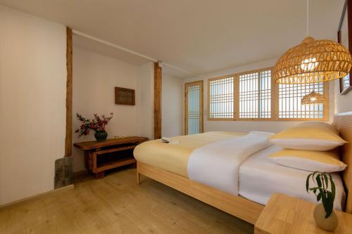 a bedroom with a large bed and a table at Lijiang half yard hotel in Lijiang