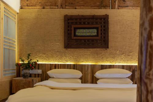 a room with four beds and a picture on the wall at Lijiang half yard hotel in Lijiang