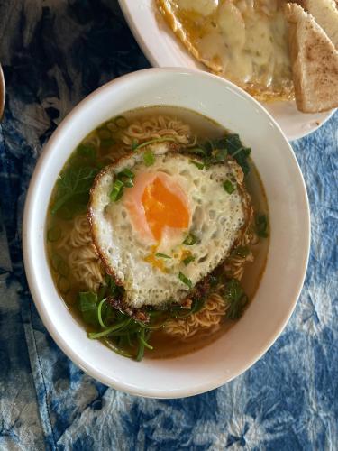 a bowl of soup with an egg on top of noodles at Hmong Farmstay in Sa Pa